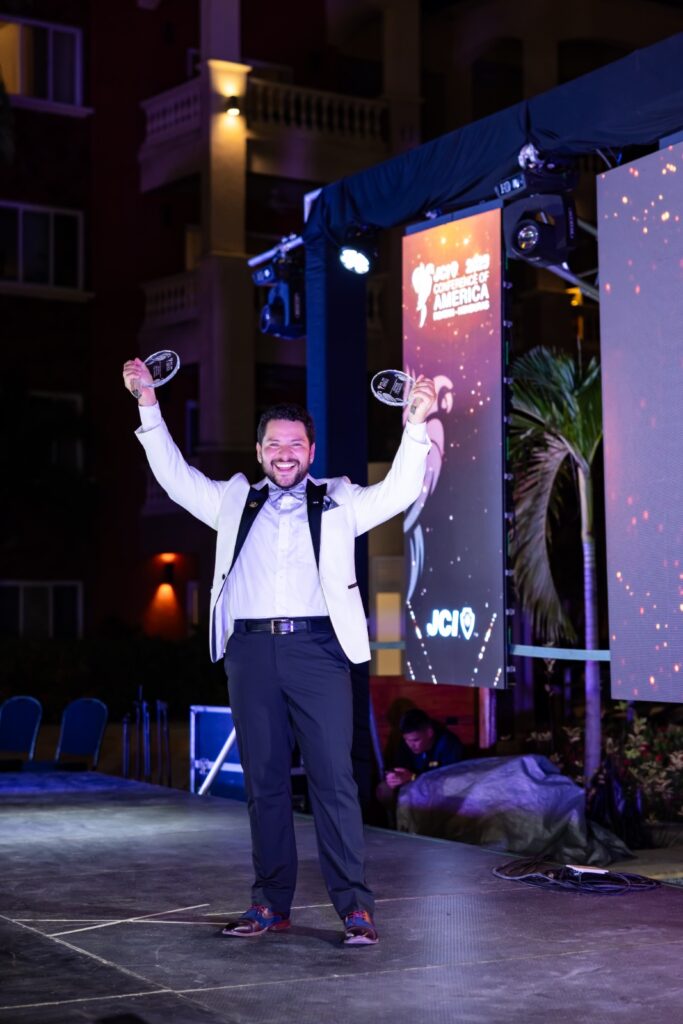 Ángel sosteniendo sus dos reconcimientos.